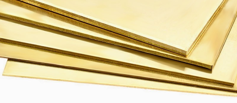 A stack of polished brass sheets, a versatile material for fashion jewelry.