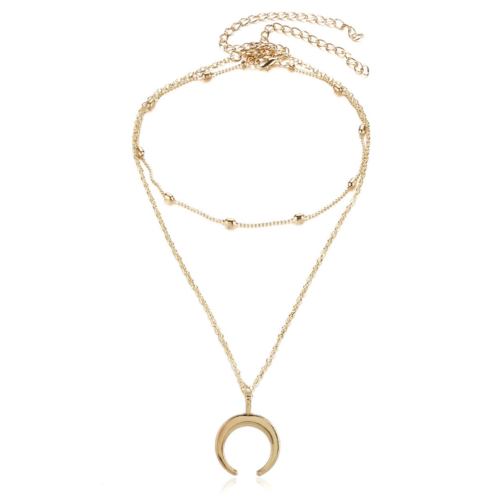 Detailed view of the Gold Crescent Pendant Necklace on a neutral background