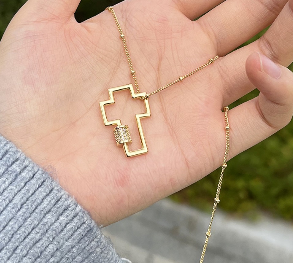 Close-up of a custom gold cross necklace pendant