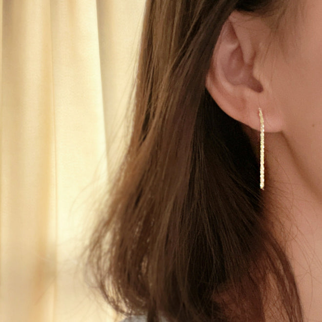 Model wearing the gold dangling sterling silver earring