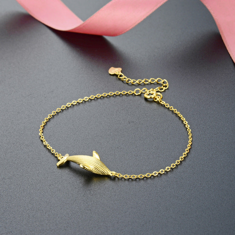 A similar gold bracelet from the collection featuring a dolphin charm
