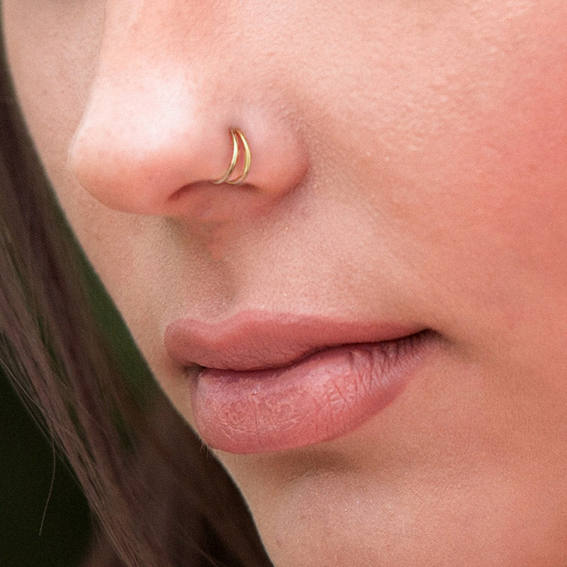 A close-up of the gold double hoop fake nose ring being worn