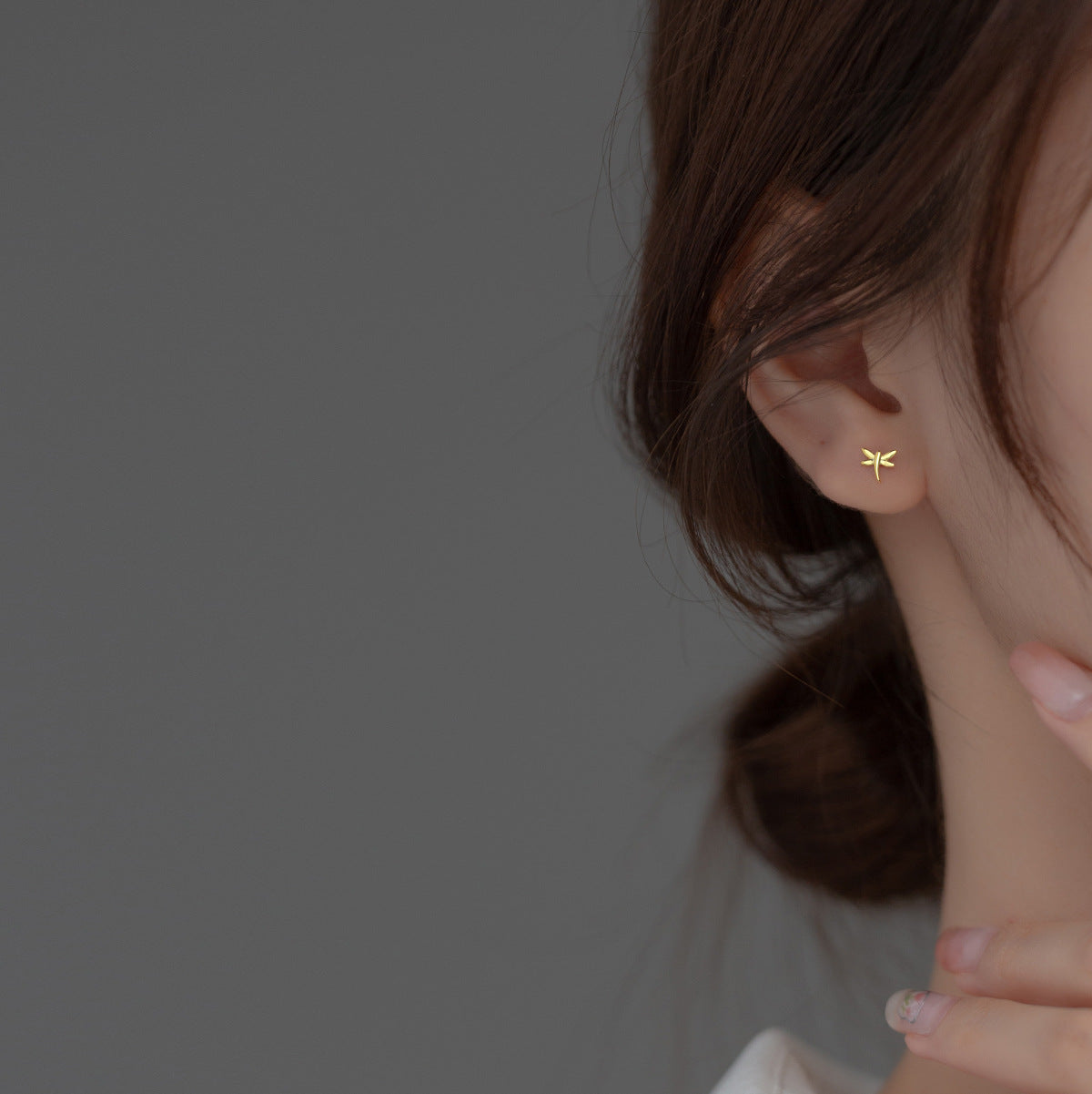 Model wearing the gold mini dragonfly stud earring.