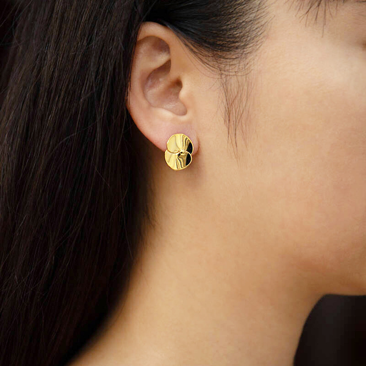 A model wearing the gold double disc stud earring to showcase its elegant look.