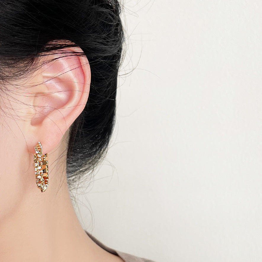 Model wearing one of the 14K gold-plated hoop earrings to showcase its elegant fit.