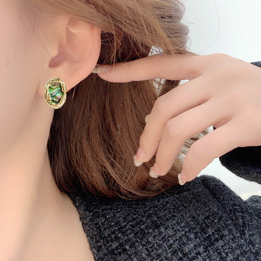 A model showcasing the elegant fit of the abalone shell stud earring.