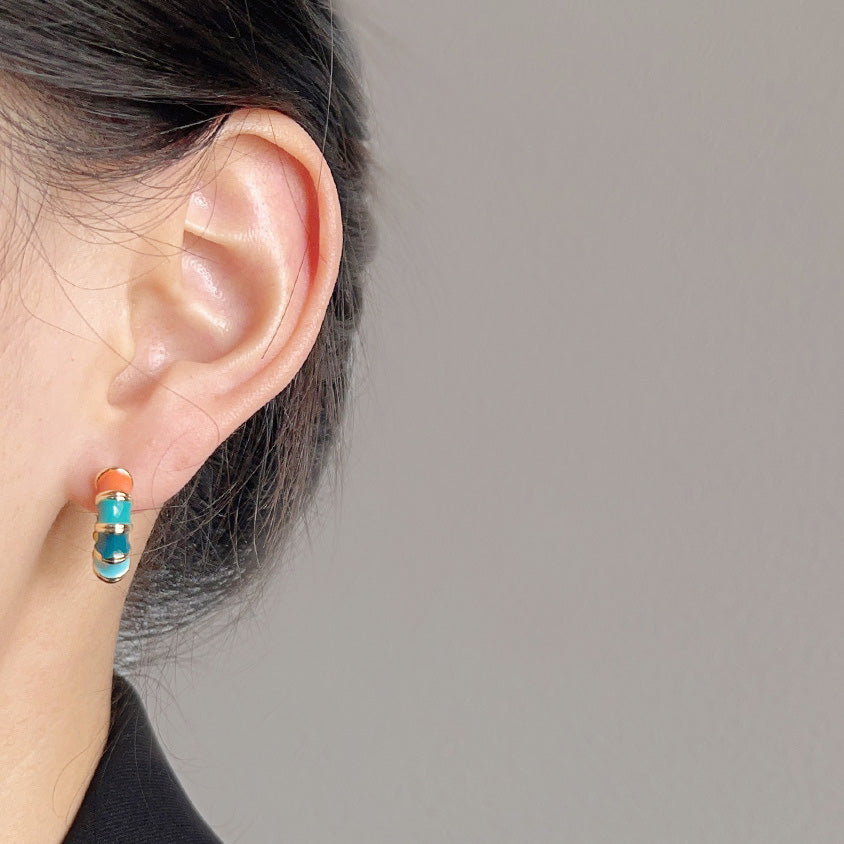 A model wearing the colorful enamel bamboo hoop earring to showcase its size and style.