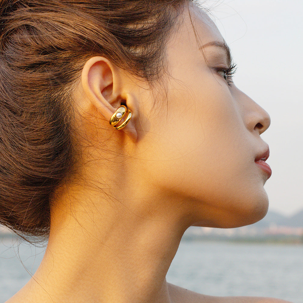 A woman wearing the gold stainless steel pearl ear cuff to show its elegant fit.