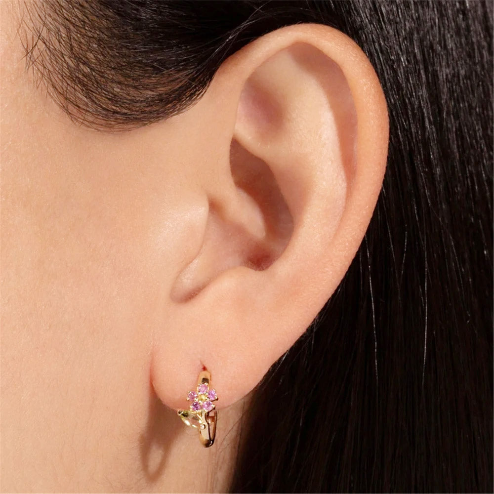 Detailed view of the flower hoop earring with a vibrant purple cubic zirconia stone