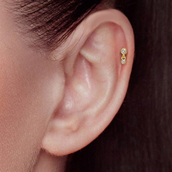 Model wearing the two-stone cubic zirconia stud earring in gold finish.
