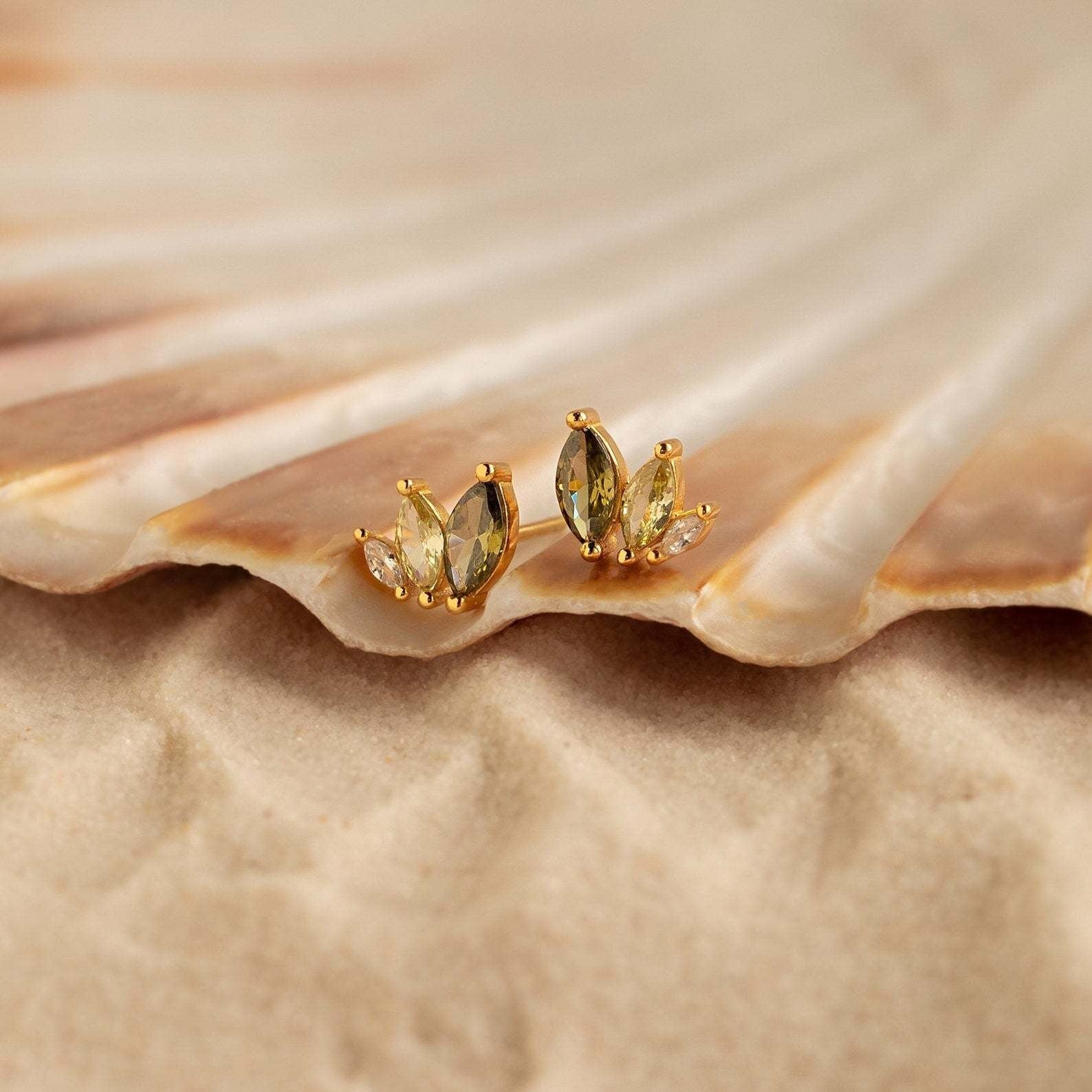 S925 marquise cut CZ stud earrings with gold plating displayed with a seashell to evoke a summer beach theme.