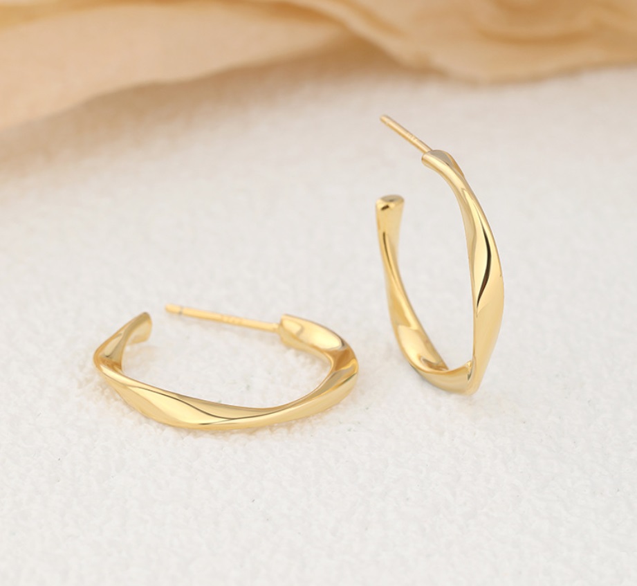 Side profile of the gold-plated sterling silver circle earrings highlighting their unique curved shape