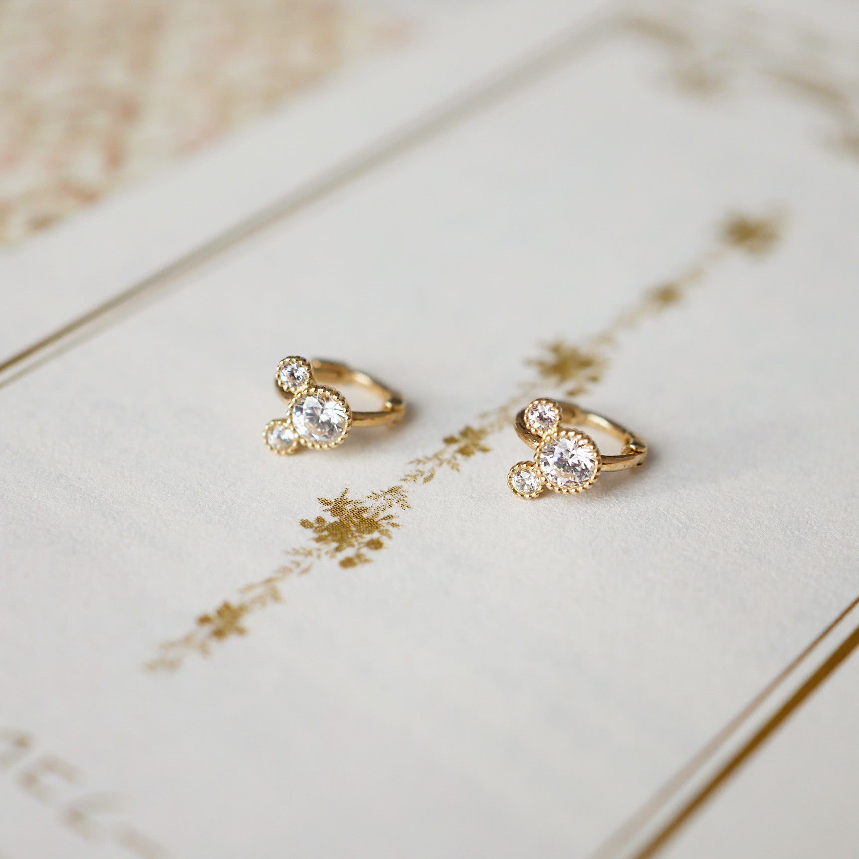 Detailed product view of the sterling silver huggie hoop earrings with CZ stones