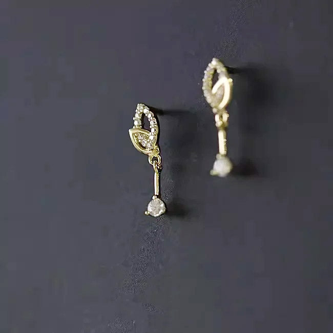 A pair of 14K gold plated leaf drop earrings showcasing their brilliant AAA+ cubic zirconia stones.