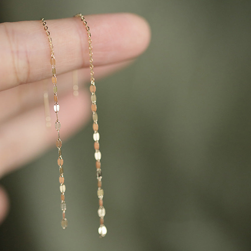 Detailed view of the 14K gold plated tassel earrings with oval beads