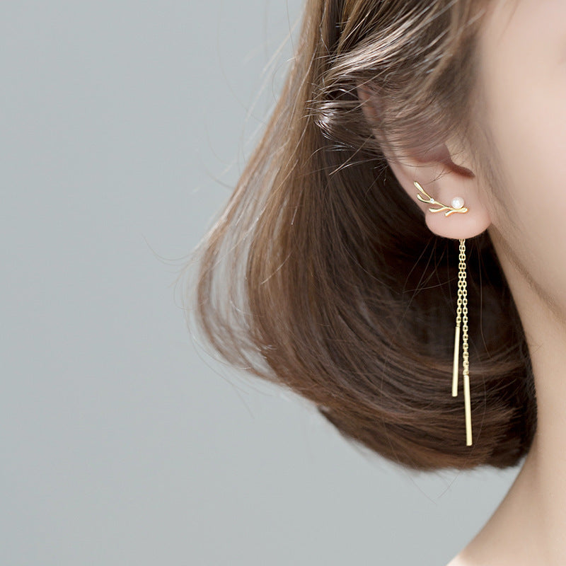 A model showcasing the elegant drape of the gold antler pearl drop earrings.
