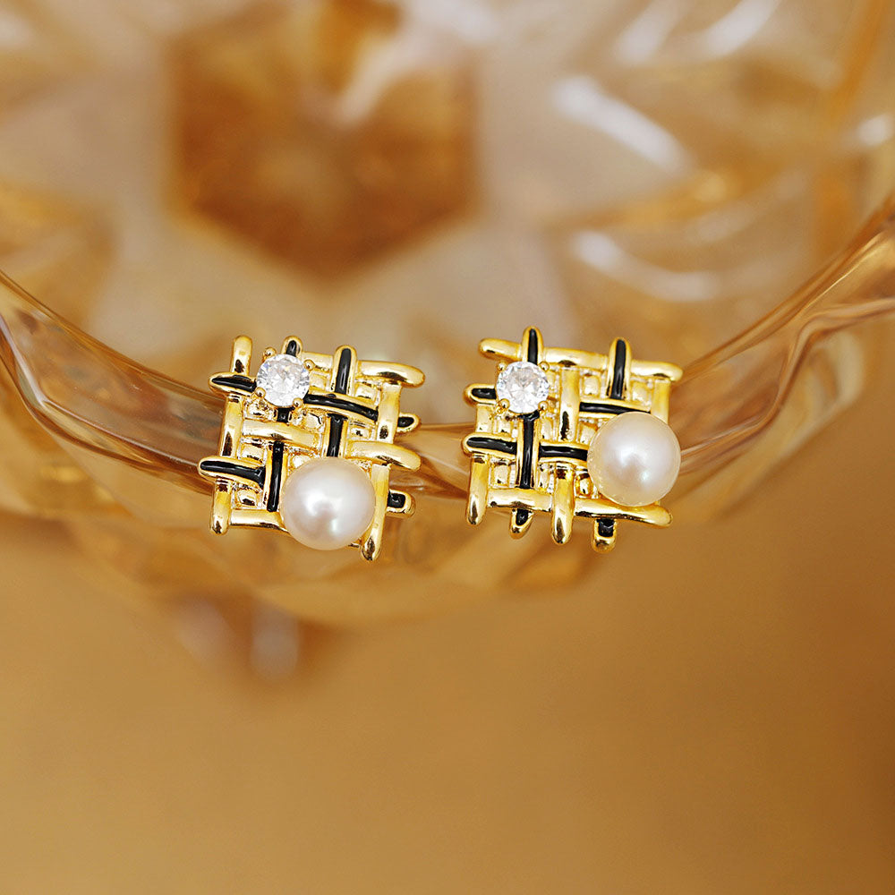 Detailed view of the braided mesh stud earrings with black enamel accents