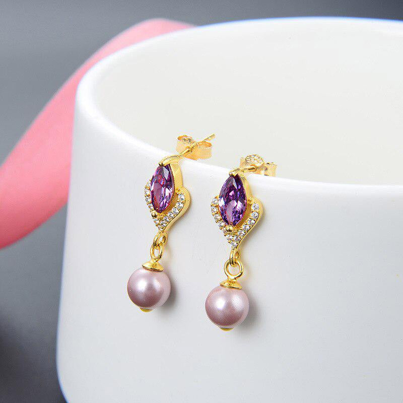 A pair of 925 sterling silver earrings with purple gemstones and pink pearls on a gold-tone setting.