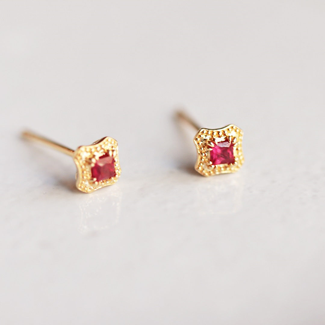 Detailed view of the vintage gold and ruby red stone earrings