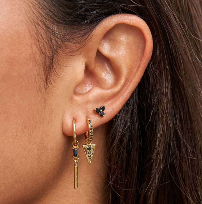 Detailed view of the individual gold earrings with various designs and stone settings