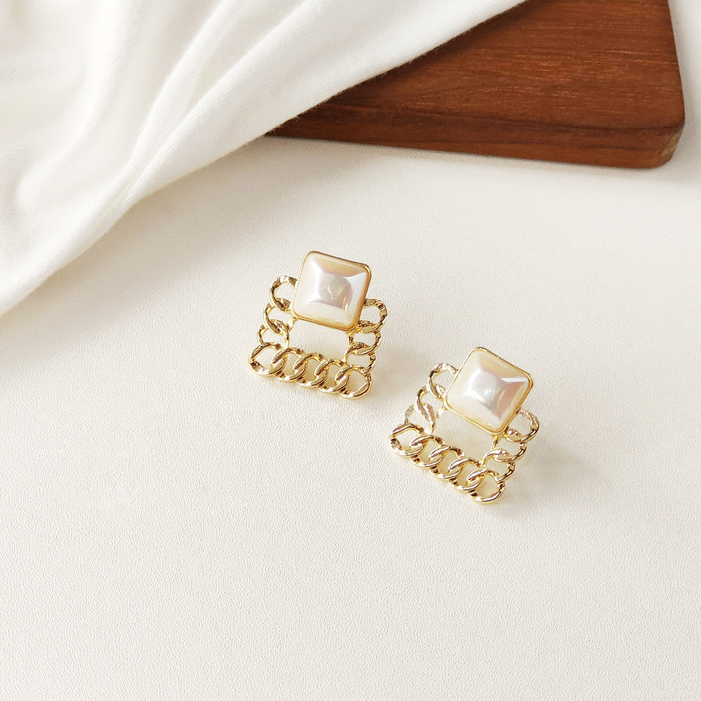 A collection of five pairs of French style gold plated pearl stud earrings on a white background.