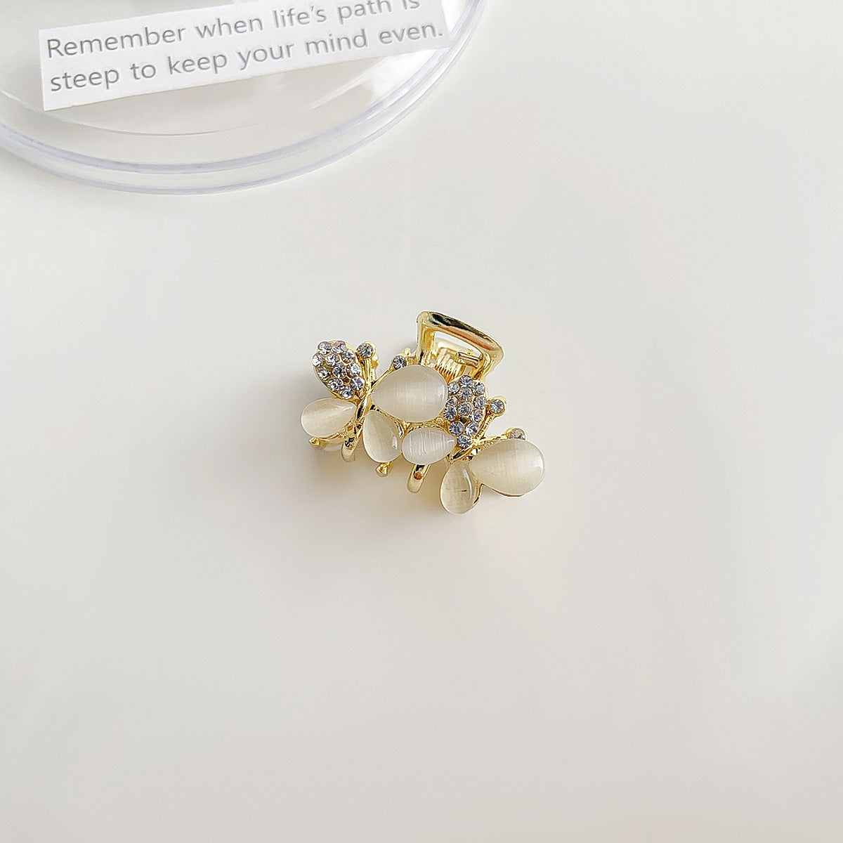 Detailed close-up of a gold floral hair clip with white stones and rhinestones