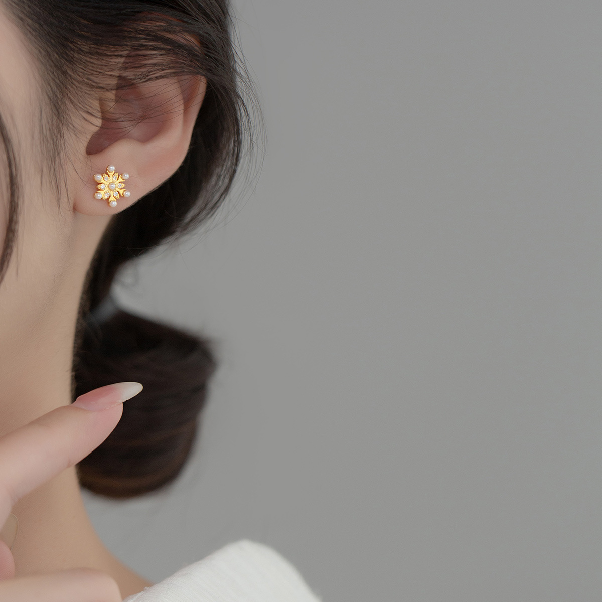 Model wearing the 925 silver gold snowflake pearl stud earrings