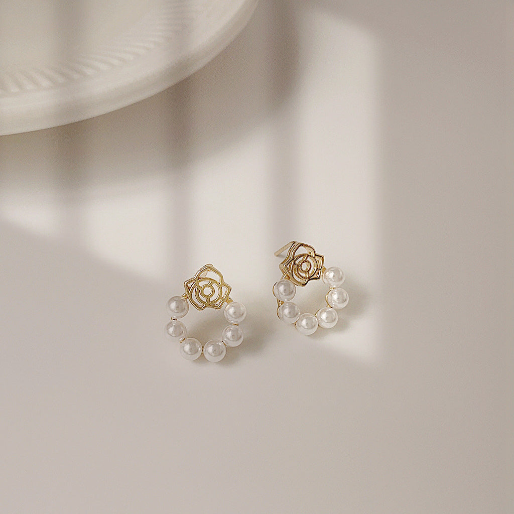 Detailed view of the gold floral pearl earrings