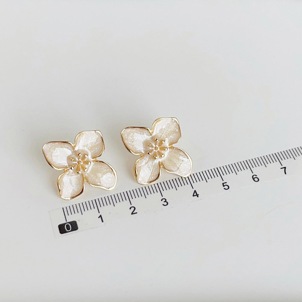 Size reference for the gold-plated white enamel flower stud earrings
