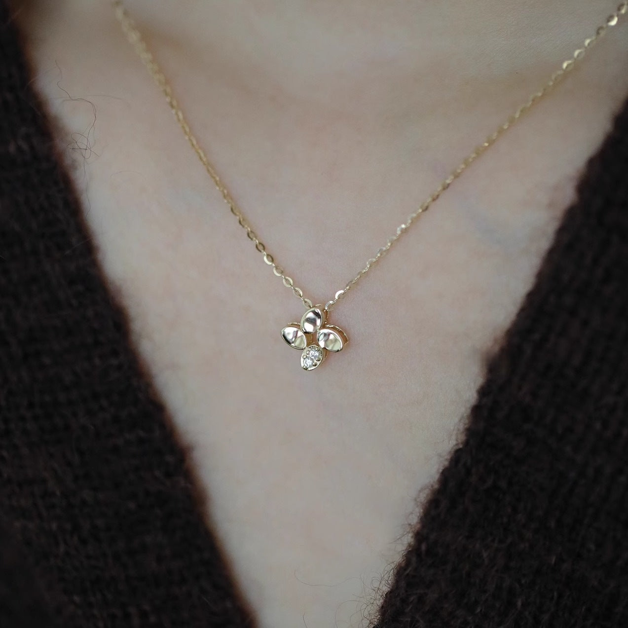 Model showcasing the 14K gold plated four-leaf flower necklace.