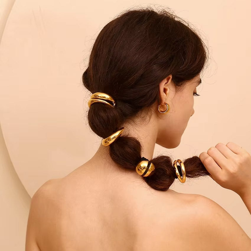 A woman wearing the gold lip shape hair tie in her ponytail