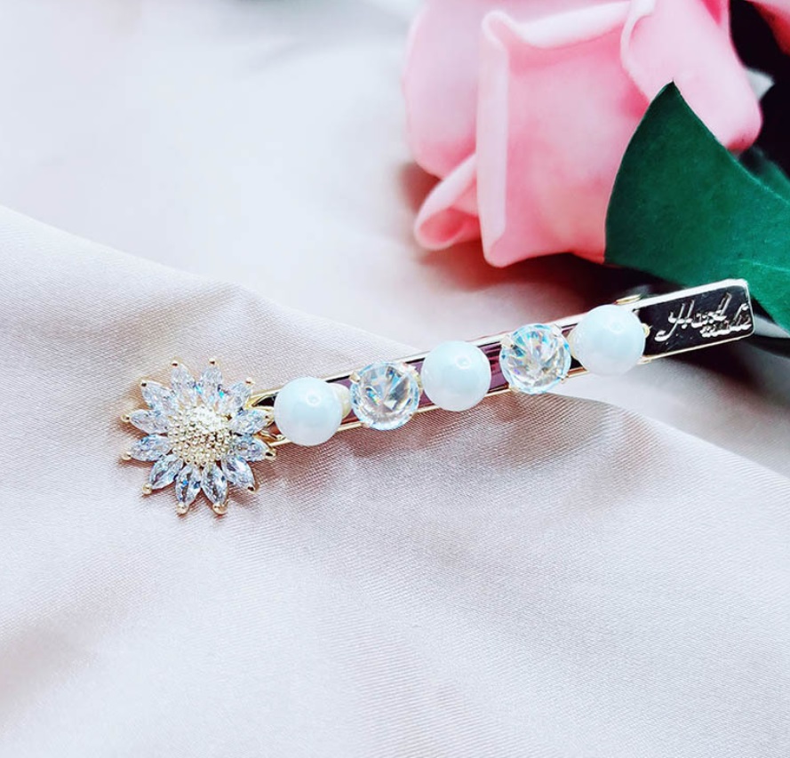 Detailed view of the Sunflower Pearl Crystal Hair Pin with flower gemstone and white bead decoration