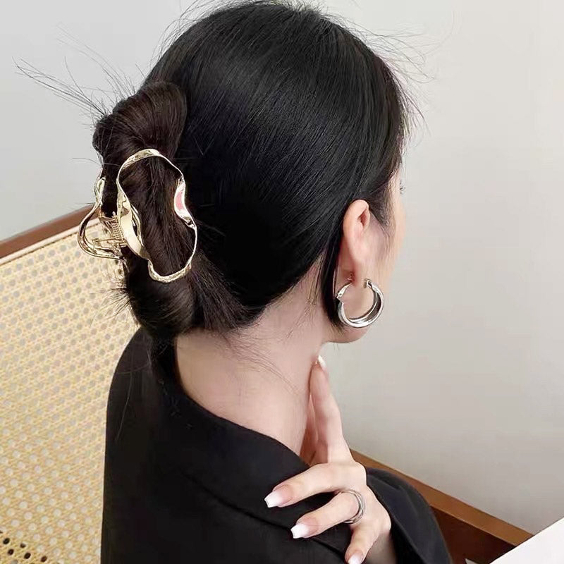 A model showcasing the gold cloud-shaped wave hair clip in an elegant bun.