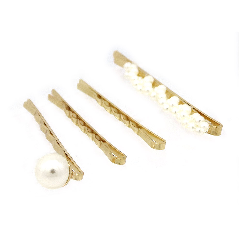 Detailed view of the gold hair clips with pearl decorations