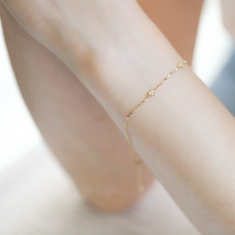 Model wearing the delicate gold heart charm bracelet