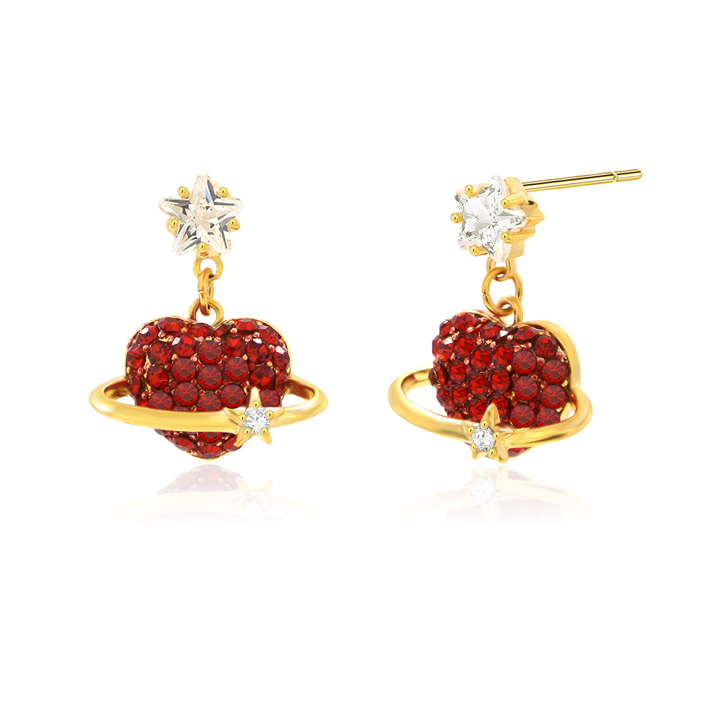 Detailed view of the gold heart earrings with red gemstones