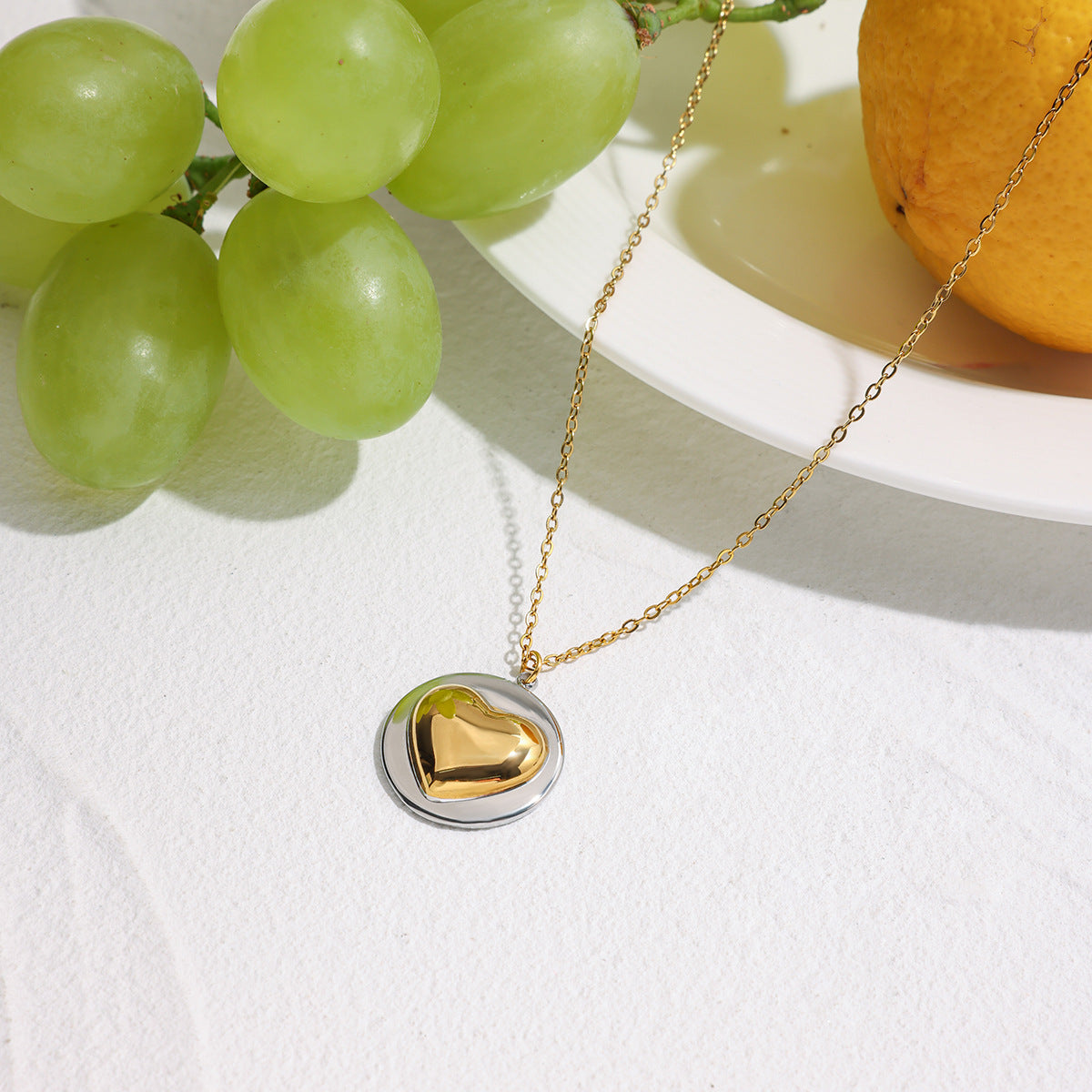 Model wearing the two-tone heart pendant necklace