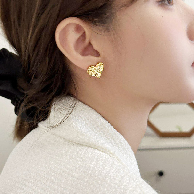 A model wearing the gold irregular heart-shaped stud earring.