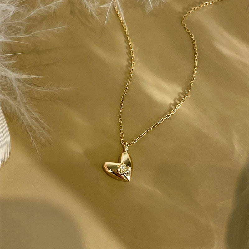 Detailed view of the starburst design on the gold heart-shaped pendant.