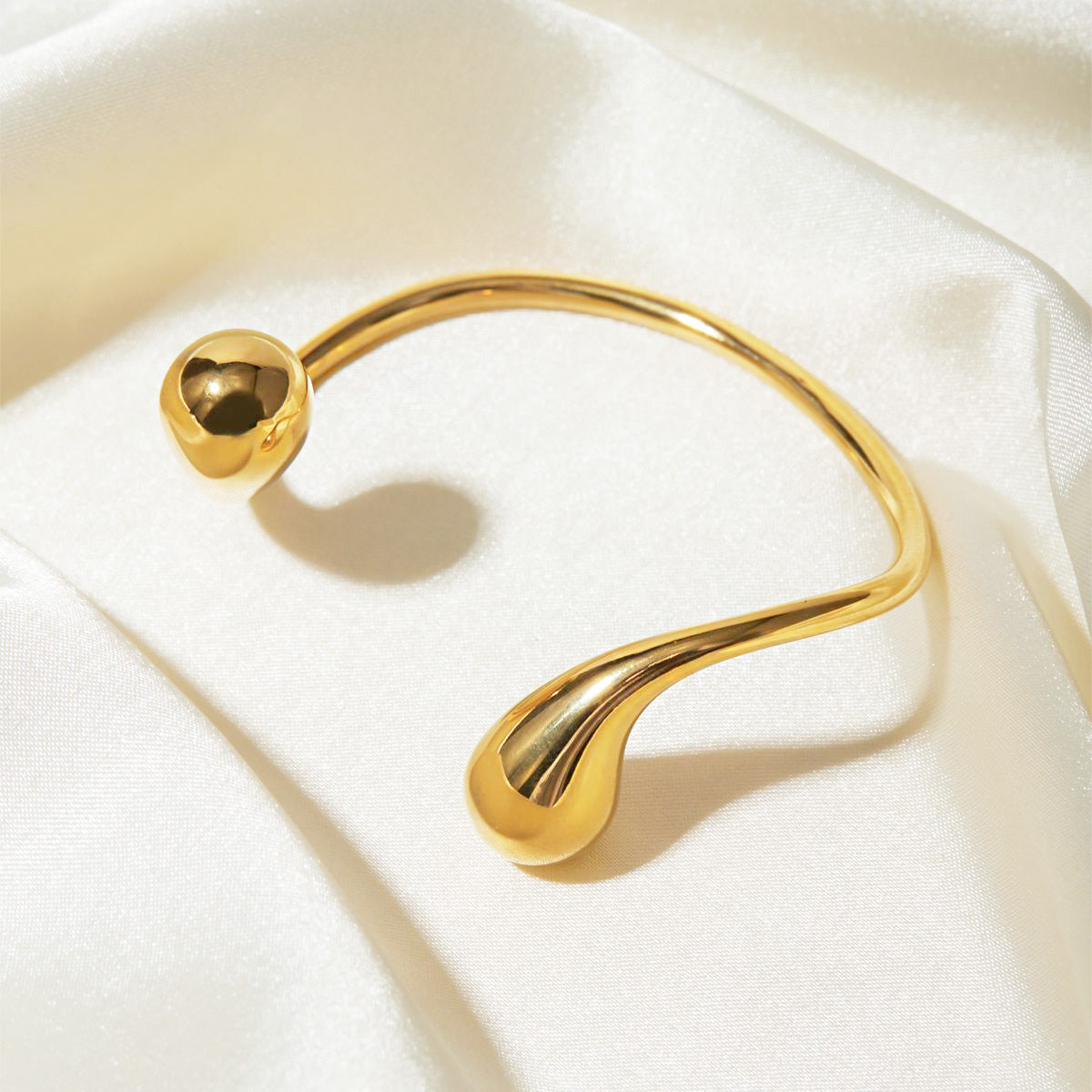 Detailed view of the gold asymmetric cuff bangle's unique design
