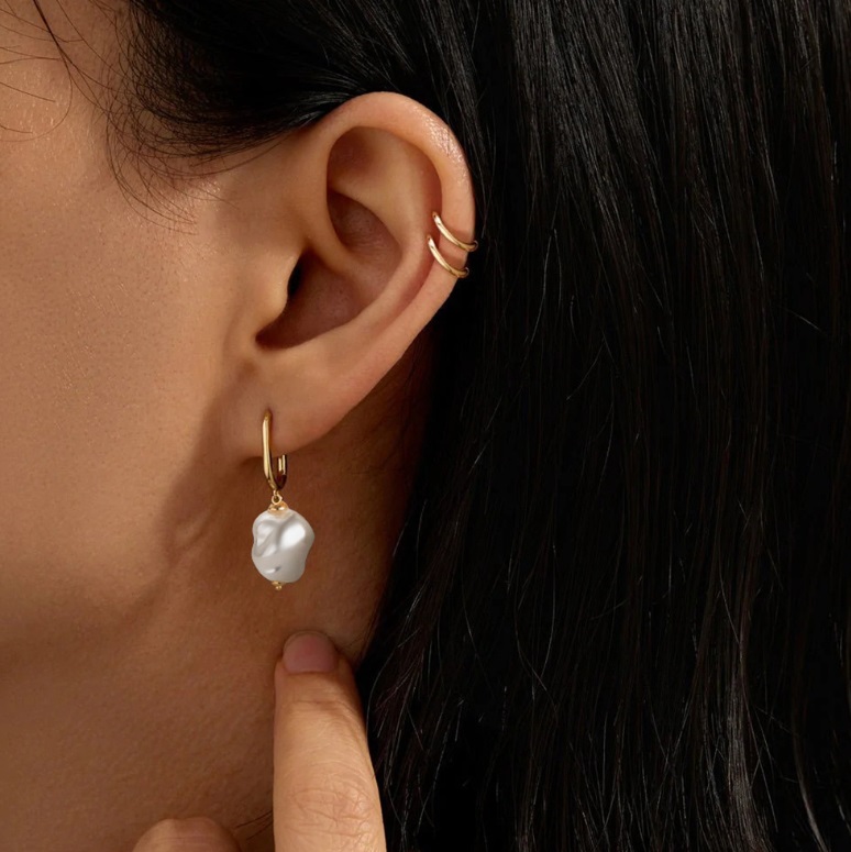 Close-up of the unique baroque pearl on the gold hoop earring