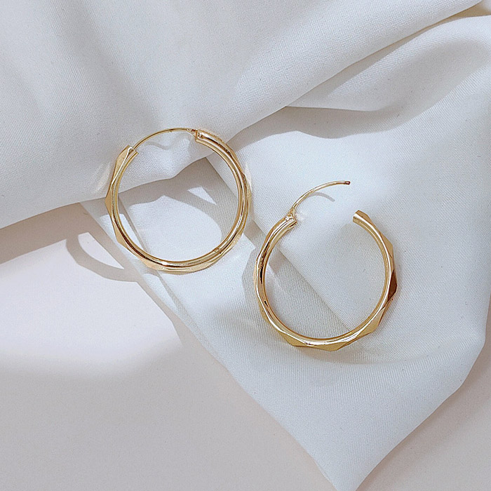 The 28mm Infinity Hoop Earrings displayed on a clean white fabric background.