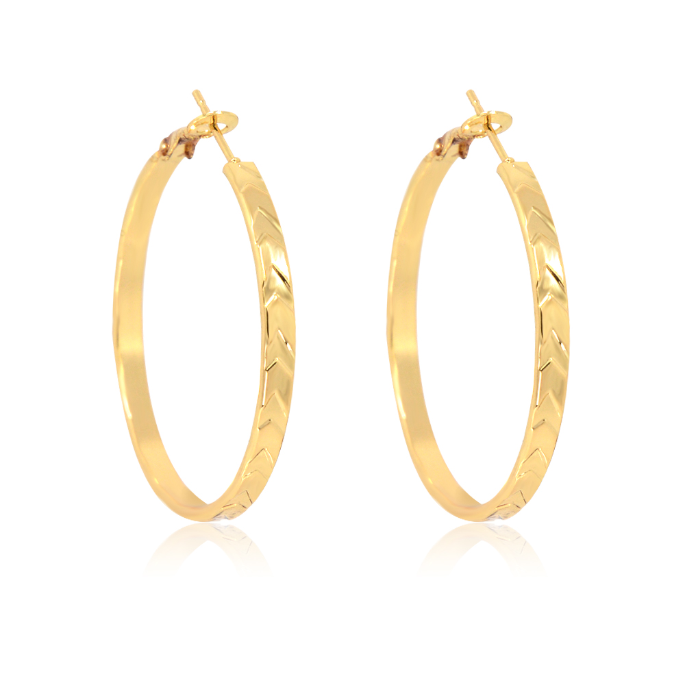 Detailed view of the textured surface on the gold diamond-cut hoop earrings