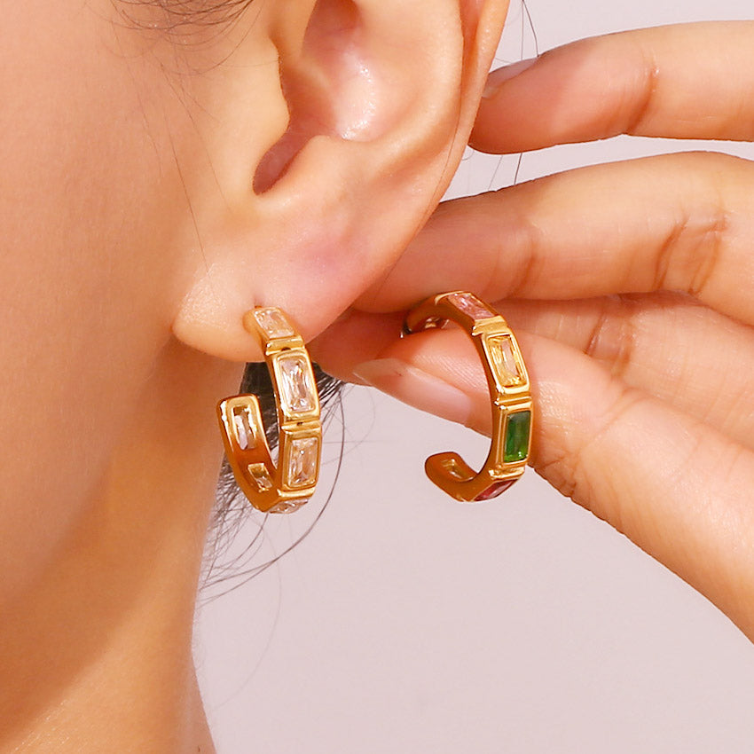 A model wearing the stylish gold-plated bamboo C-shaped earrings with green and clear zircon stones.