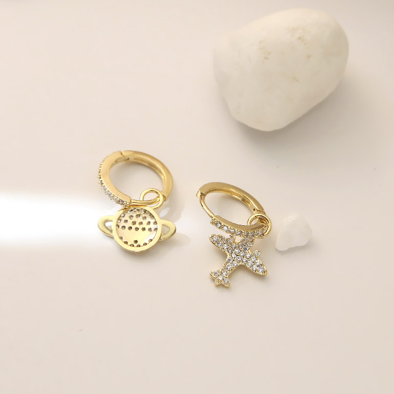 Full view of the gold hoop earrings with planet and star charms