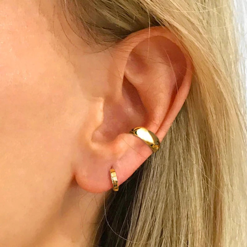 A woman wearing the gold chunky C-shape ear cuff to show its comfortable fit.