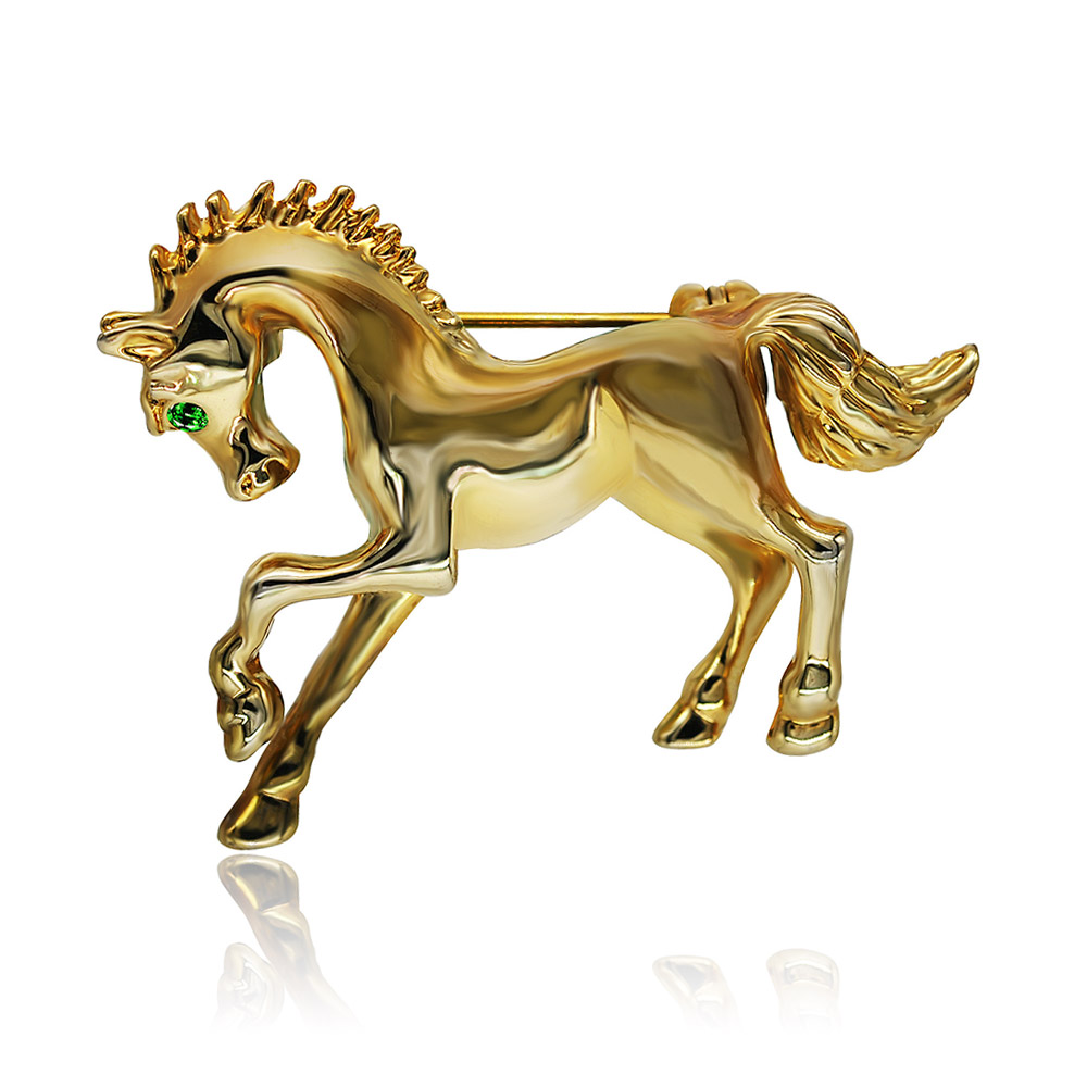Close-up of the gold horse brooch with emerald eye