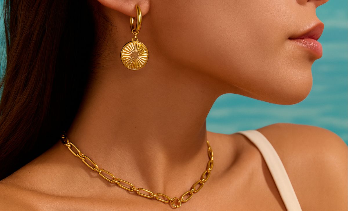 Close-up of a model wearing a gold stainless steel necklace and earrings, highlighting the jewelry's brilliant shine.