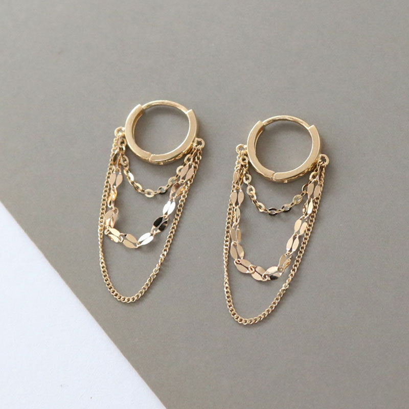 A close-up of the intricate gold layered chain huggie earrings from the set.