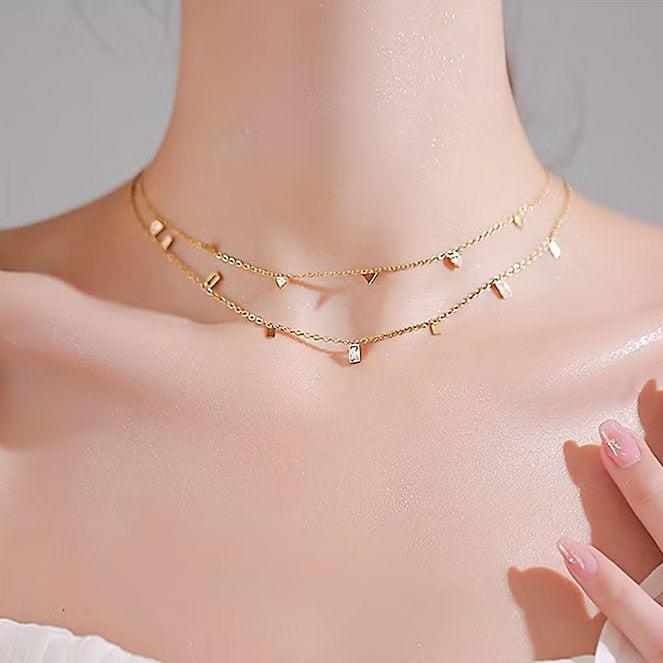 Model showcasing the layered look of the geometric charm necklaces